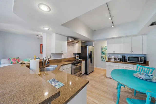 a view of a dining room with furniture a chandelier and wooden floor