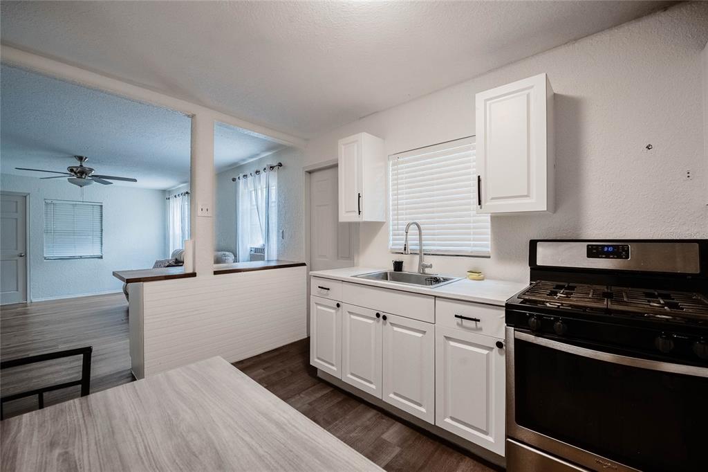 5 North Street Frostproof, FL 33843 - Photo 15 of 22 a kitchen with granite countertop a sink cabinets and stainless steel appliances