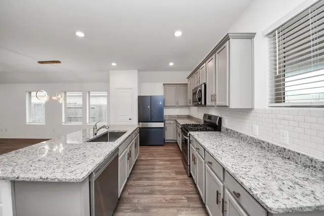 a kitchen with granite countertop counter top space a sink stainless steel appliances and cabinets