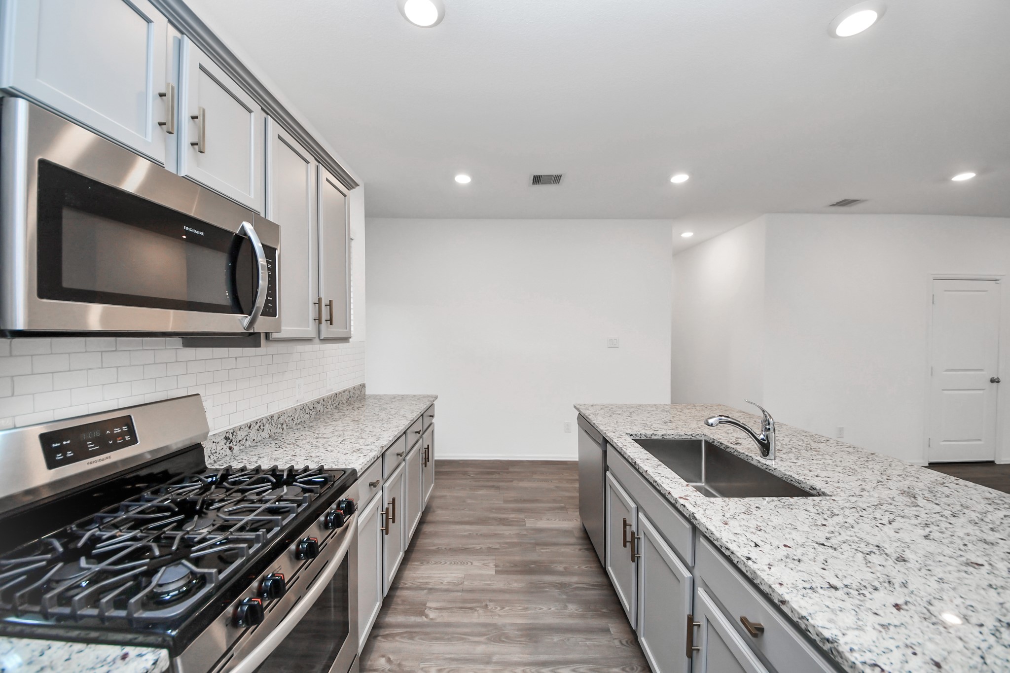 14230 Elrington Holw Trail Rosharon, TX 77583 - Photo 21 of 42 a kitchen with stainless steel appliances kitchen island granite countertop a stove and a sink