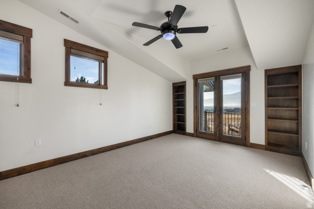 707 Chimney Rock Road, Unit 247 Heber City, UT 84032 - Photo 27 of 64 Carpeted spare room featuring built in features, healthy amount of natural light, ceiling fan, and vaulted ceiling