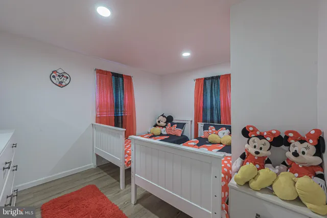 a living room with a baby crib furniture and a wooden floor