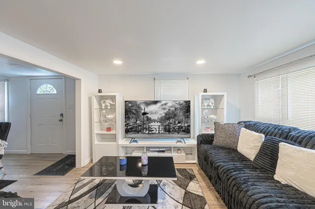 a living room with furniture and view of kitchen