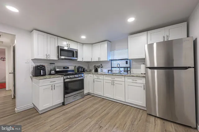 a kitchen with cabinets stainless steel appliances a sink and a refrigerator