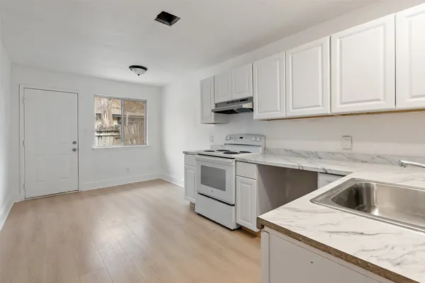 a kitchen with granite countertop white cabinets and white appliances