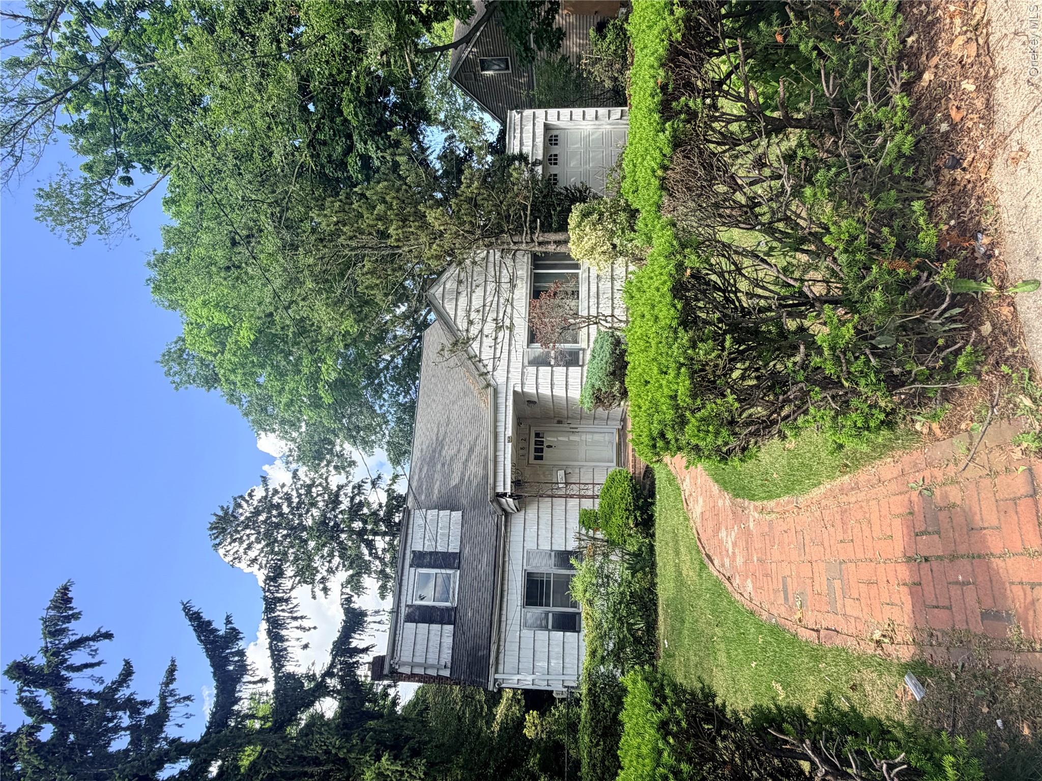 182 East Rockaway Road Hewlett, NY 11557 - Photo 1 of 8 Traditional-style residence featuring white siding and a dormer window