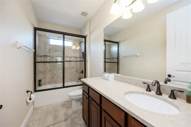 a bathroom with a granite countertop sink a large mirror and a shower