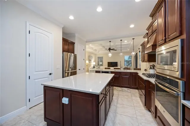 a kitchen with kitchen island a sink stove and refrigerator