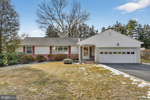 a front view of house with yard and trees in the background