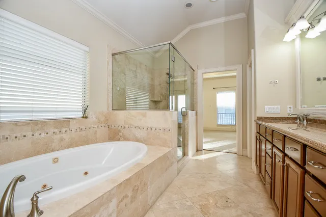 a spacious bathroom with a tub sink shower and mirror
