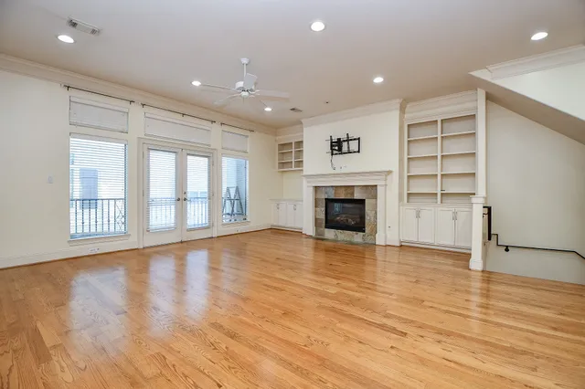 a view of an empty room with a window and fireplace