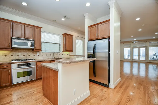 a kitchen with stainless steel appliances granite countertop a refrigerator sink and stove