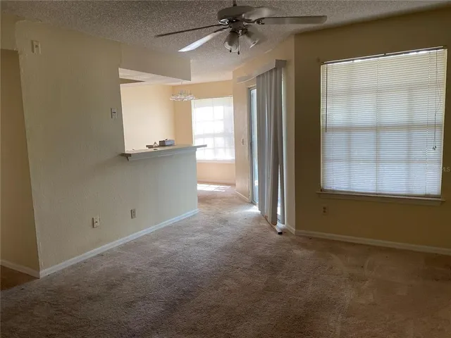 an empty room with windows and cabinet