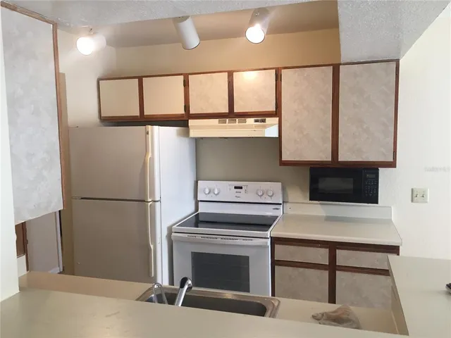 a kitchen with a stove a refrigerator and a fireplace