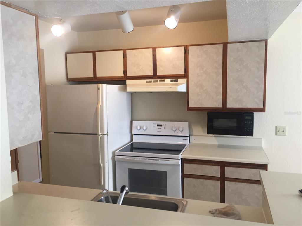 1021 South Hiawassee Road, Unit 3914 Orlando, FL 32835 - Photo 4 of 6 a kitchen with a stove a refrigerator and a fireplace