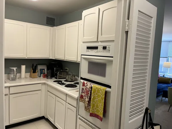 a kitchen with stainless steel appliances white cabinets and a refrigerator