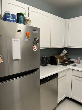 a kitchen with white cabinets and white appliances