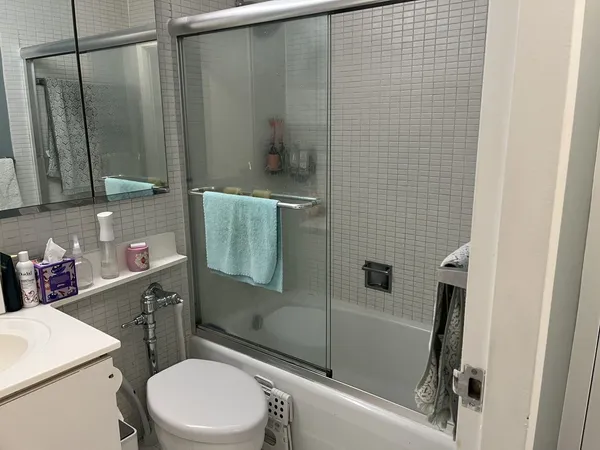 a bathroom with a sink a toilet and shower