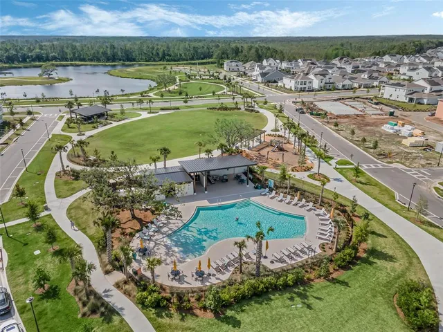an aerial view of a house with a garden and lake view