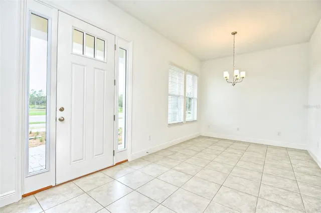 an empty room with windows and chandelier