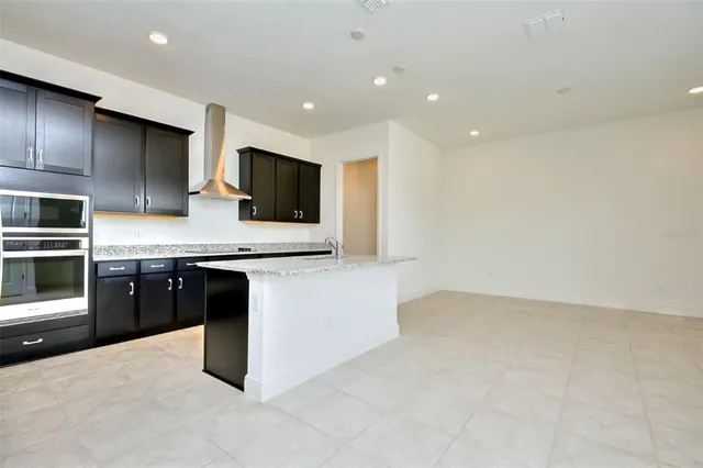 a large kitchen with stainless steel appliances granite countertop a stove a sink and a refrigerator