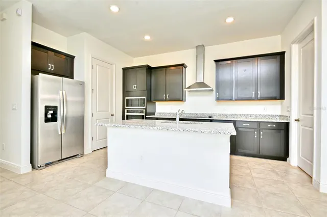 a kitchen with stainless steel appliances granite countertop a refrigerator and a sink