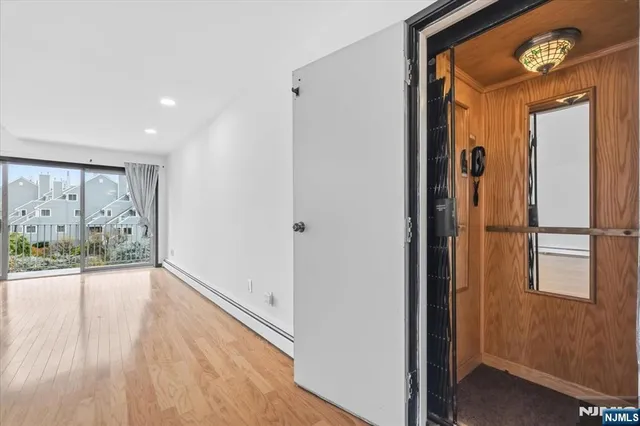a view of empty room with wooden floor and fireplace