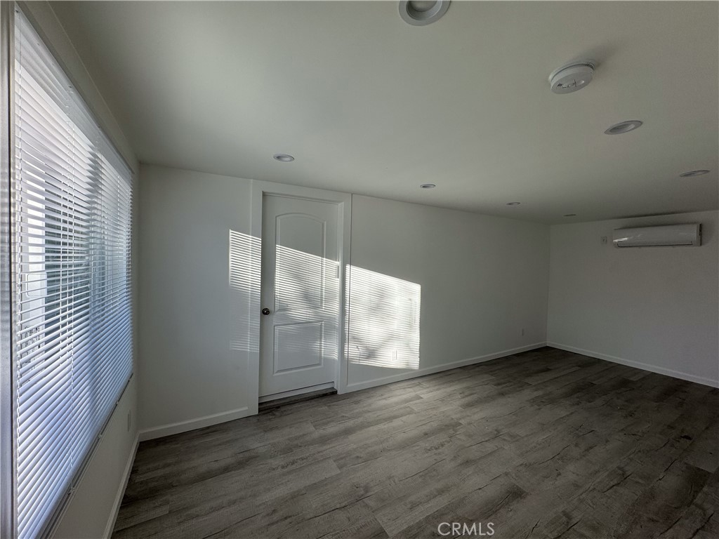 19351 1/2 Strathern Street Reseda, CA 91335 - Photo 7 of 9 an empty room with wooden floor and windows