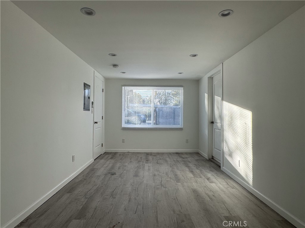 19351 1/2 Strathern Street Reseda, CA 91335 - Photo 8 of 9 a view of an empty room with a window and wooden floor
