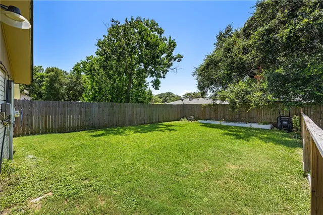 a view of garden with wooden fence