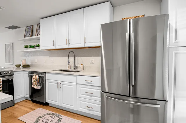 a kitchen with stainless steel appliances granite countertop a sink refrigerator and cabinets