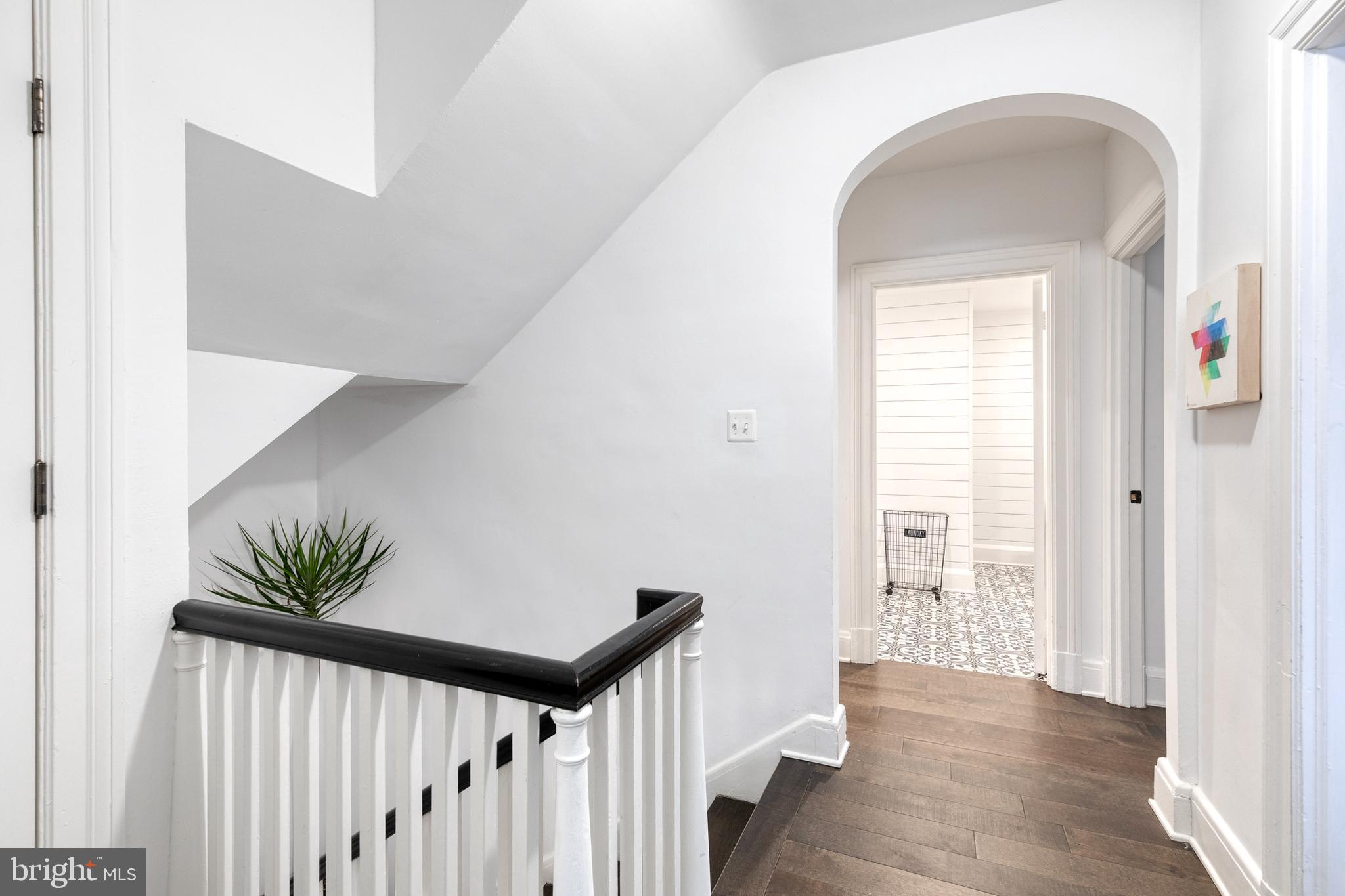 103 Witherspoon Road Baltimore, MD 21212 - Photo 48 of 62 a view of a hallway to a livingroom with wooden floor and stairs