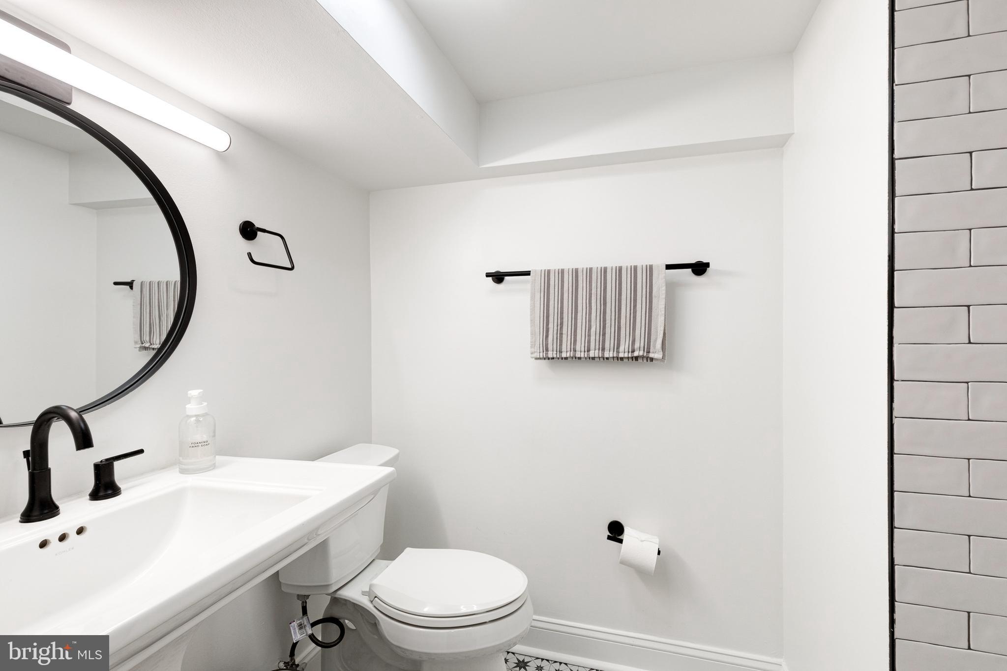 103 Witherspoon Road Baltimore, MD 21212 - Photo 59 of 62 a bathroom with a sink a toilet and a mirror