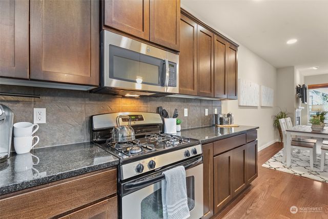 a kitchen with stainless steel appliances granite countertop a refrigerator a stove a sink and dishwasher
