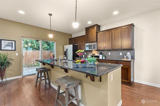 a kitchen with kitchen island a sink appliances and a counter top space
