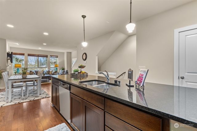 a kitchen with stainless steel appliances granite countertop a stove a sink and a microwave