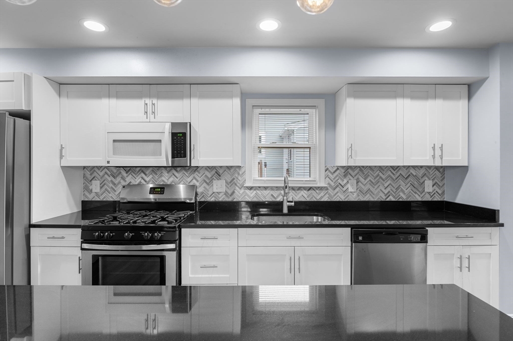 15 R Argyle Street Revere, MA 02151 - Photo 11 of 32 a kitchen with granite countertop white cabinets and stainless steel appliances