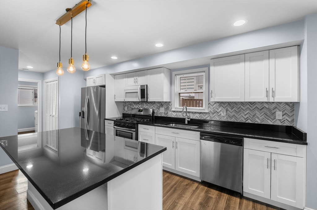 15 R Argyle Street Revere, MA 02151 - Photo 12 of 32 a kitchen with stainless steel appliances granite countertop a sink a stove and a refrigerator