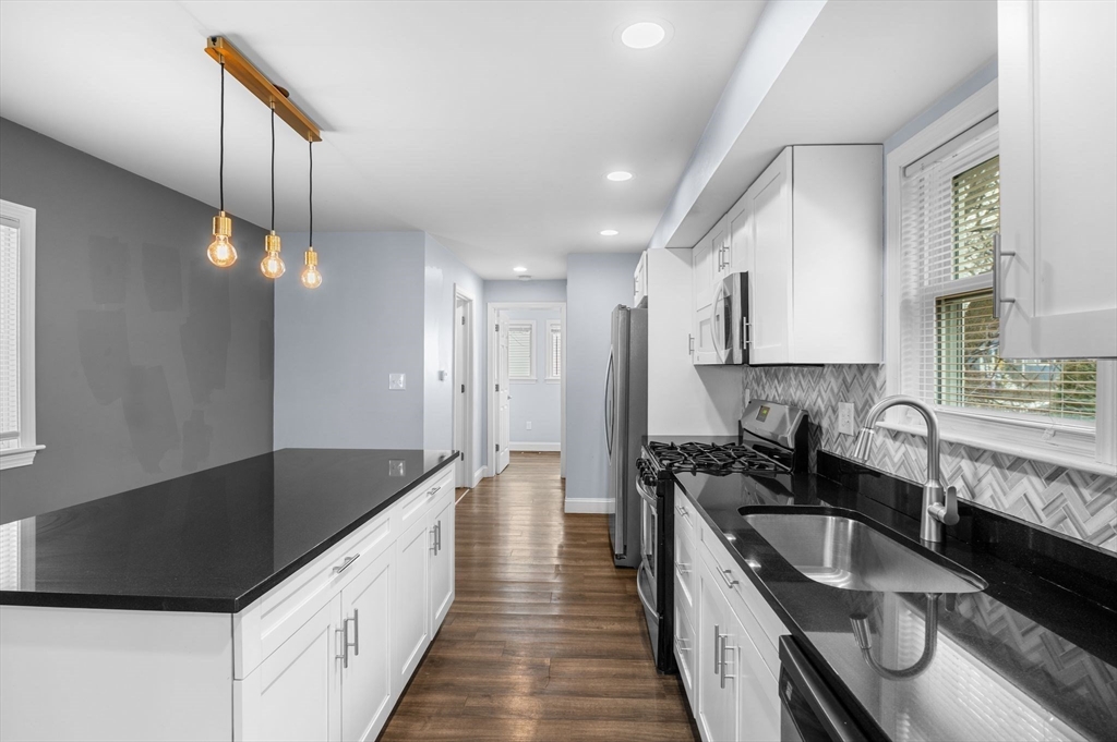 15 R Argyle Street Revere, MA 02151 - Photo 13 of 32 a kitchen with granite countertop a sink a counter space appliances and cabinets