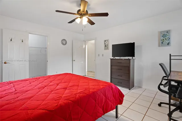 a spacious bedroom with a bed and a flat screen tv