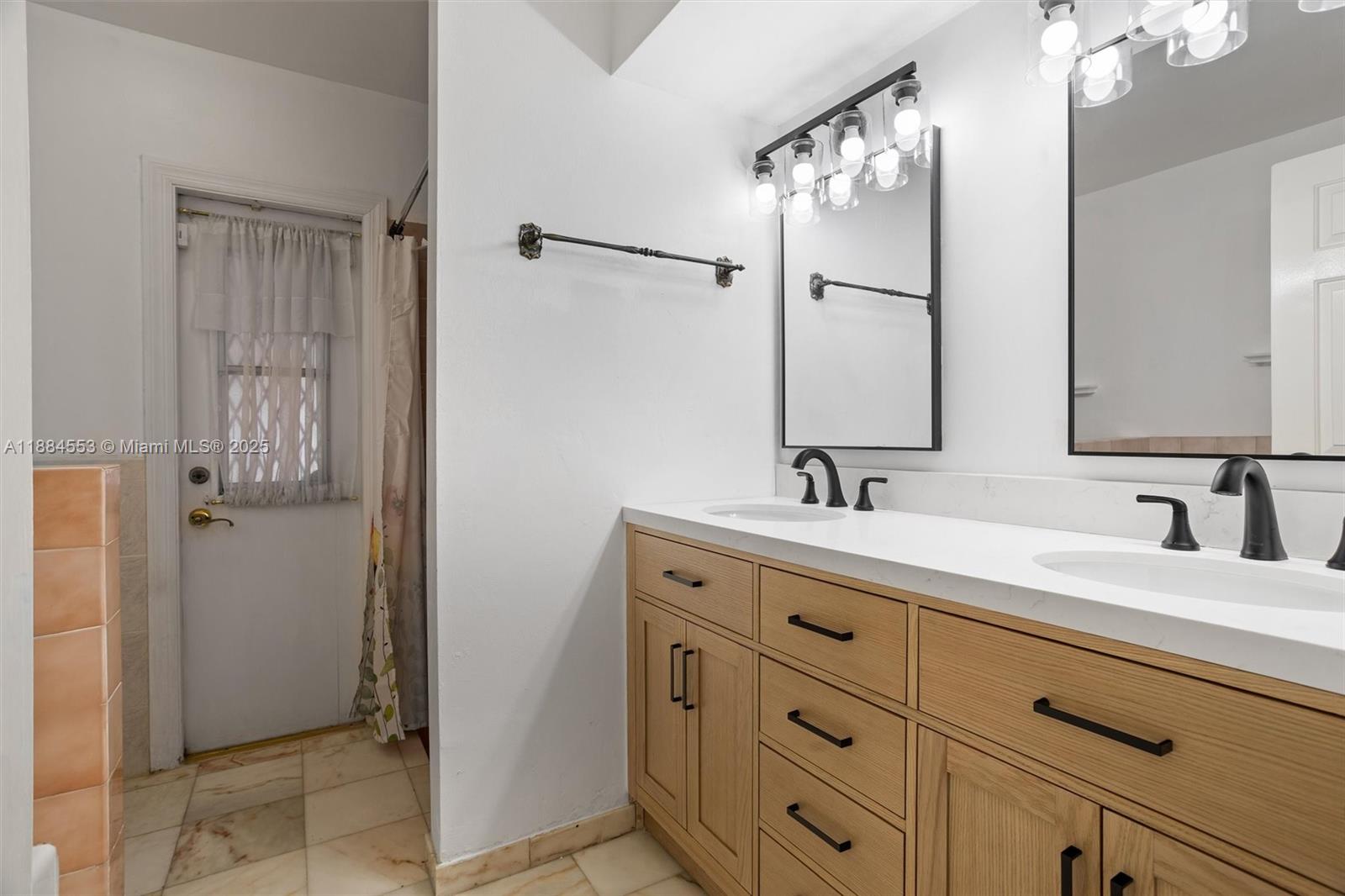 9031 North New River Canal Road Plantation, FL 33324 - Photo 17 of 32 a bathroom with a double vanity sink and mirror