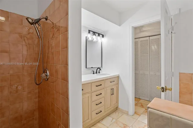 a bathroom with a granite countertop sink a mirror a vanity and a shower