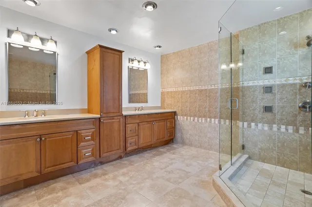a spacious bathroom with a double vanity sink mirror and shower