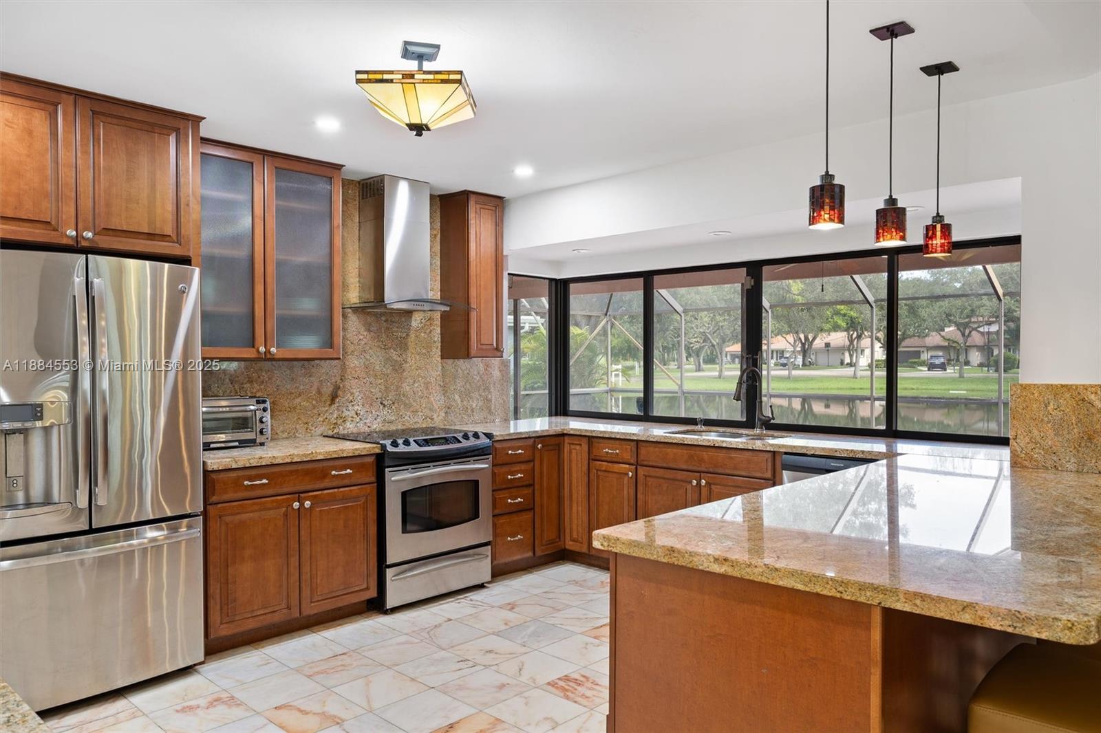 9031 North New River Canal Road Plantation, FL 33324 - Photo 3 of 32 a kitchen with stainless steel appliances granite countertop a stove and a refrigerator