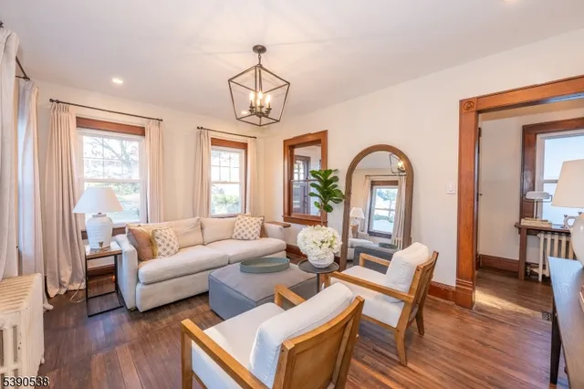 a living room with furniture chandelier and a wooden floor