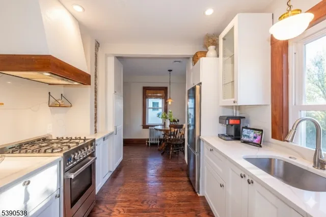 a kitchen with sink a stove and wooden cabinets