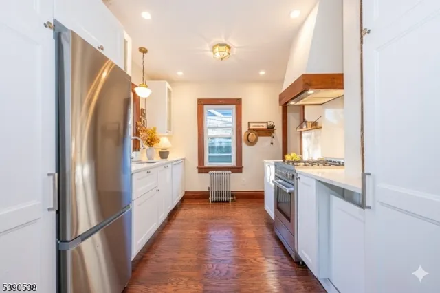 a kitchen with kitchen island wooden floor window and refrigerator