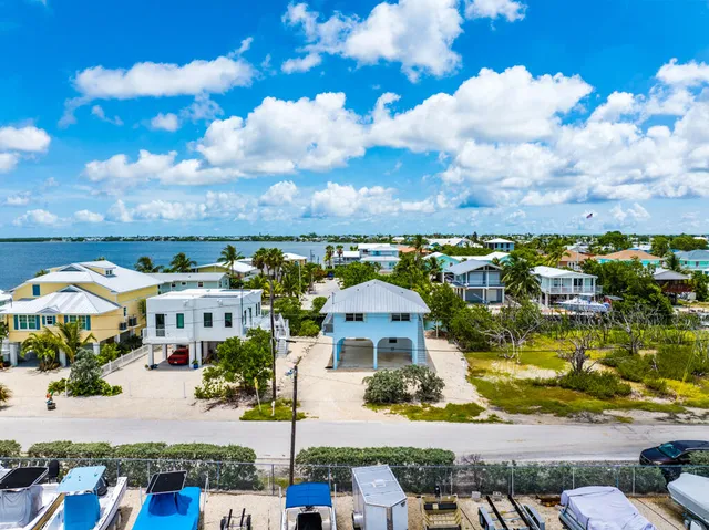 an aerial view of a house with swimming pool garden and lake view