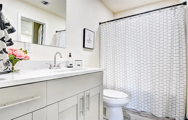 a bathroom with a sink a toilet and mirror