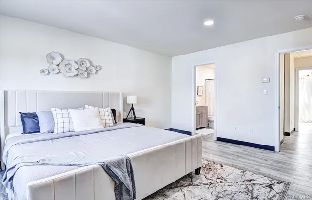 a bedroom with a large bed and wooden floor